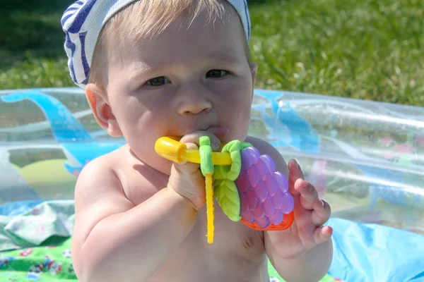 Les dents de l'enfant sont coupées. Les premières dents sont coupées, sur fond d'herbe verte — Photo