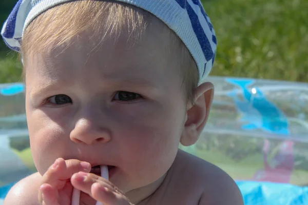 Les dents de l'enfant sont coupées. Les premières dents sont coupées, sur fond d'herbe verte — Photo