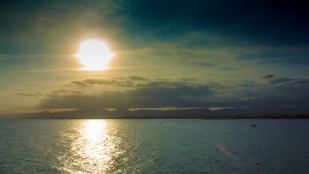 Puesta de sol en las nubes y montañas en el mar en la temporada turística con barcos y paracaídas — Vídeo de stock