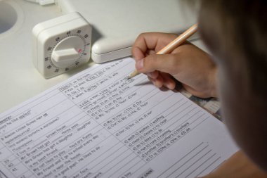 Ana sayfa eğitim. Okuldan sonra eve iş. İngilizce testi el ile geleneksel beyaz Not defteri kağıda yazı kalem çocukla. 