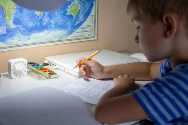 家庭教育 伝統的な白いメモ帳の紙に手で英語のテストを書くペンで少年の手 少年は 友人に手紙を書きます 放課後の家の仕事 — ストック写真