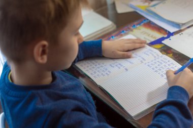 Ana sayfa eğitim. Okuldan sonra eve iş. İngilizce testi el ile geleneksel beyaz Not defteri kağıda yazı kalem çocukla. 