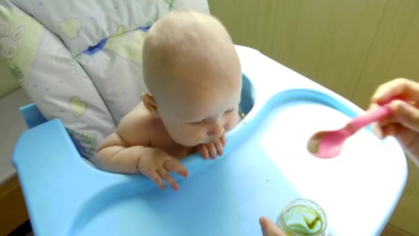 Мама кормит ребенка первой ложкой — стоковое видео