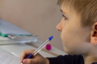 Geleneksel beyaz not defteri kağıt üzerinde elle İngilizce kelimeler yazma kalem ile erkek el yakın çekim. Çocuk ilk mektubunu İngilizce yazıyor. Çocuk yazma
