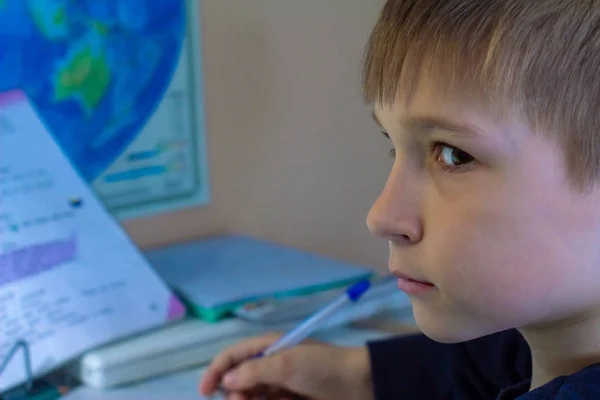 Närbild av pojke hand med blyertspenna skriva engelska ord för hand på traditionella vita anteckningsblock papper. Pojken skriver sitt första brev på engelska. Barn skrivning — Stockfoto