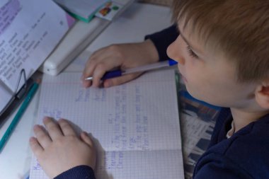 Geleneksel beyaz not defteri kağıt üzerinde elle İngilizce kelimeler yazma kalem ile erkek el yakın çekim. Çocuk ilk mektubunu İngilizce yazıyor. Çocuk yazma