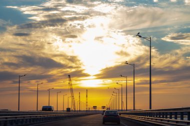 Gün batımında köprüüzerinde araba sürmek