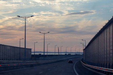 Gün batımında köprüüzerinde araba sürmek