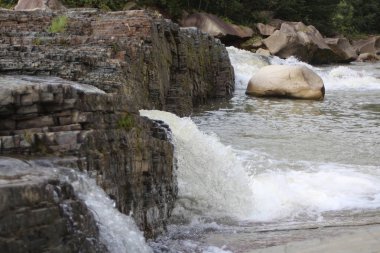 bir dağ dere hızlı su kayalar arasında fırtınalı bir şelale tarafından düşüyor