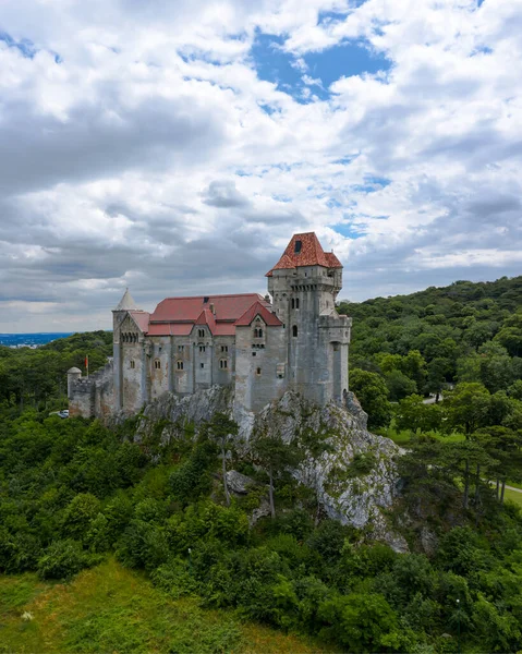 Liechtenstein Castle from the sky during sunset. The Liechtenstein Castle, situated on the southern edge of the Vienna Woods, Austria. Breathaking view about a medieval castle.