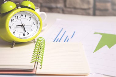 Not defterindeki saat ve masadaki kahve.