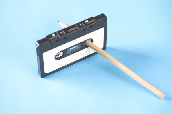 Kassette und Bleistifte auf blauem Tischhintergrund — Stockfoto
