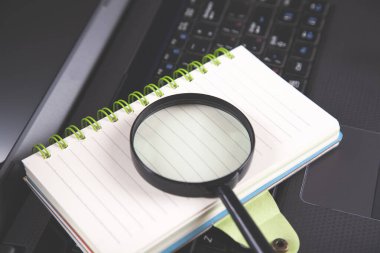 Siyah defter klavyesindeki not defterine büyüteç