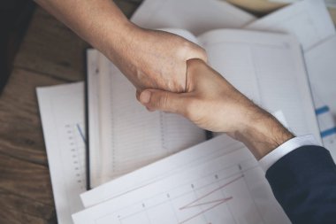 Erkek ve kadın elleri çalışma masasında.