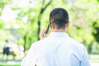 Sokakta cep telefonu tutan genç bir işadamı