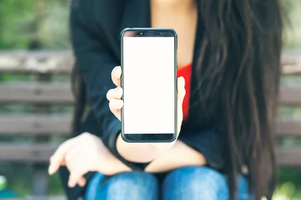 young woman holding phone template with city park background