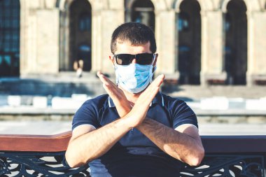 Koruyucu maskeli genç adamın portresi şehirde koronavirüsü durdurduğunu gösterdi.