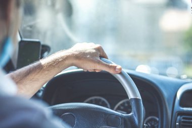 Genç ve neşeli adam yeni arabasını kullanıyor.