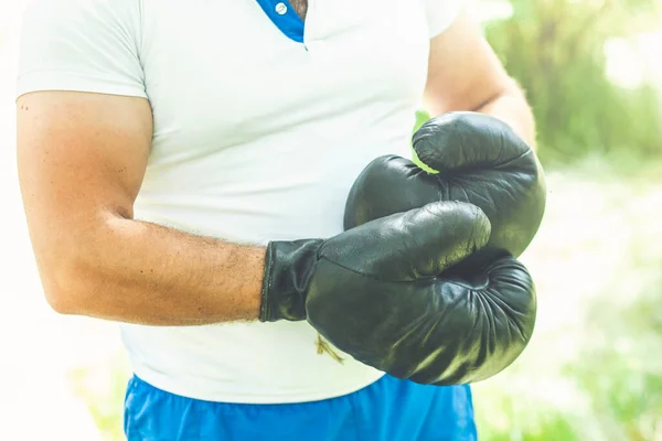 男子仰卧起坐 戴着运动手套 练习拳击 自然背景 — 图库照片