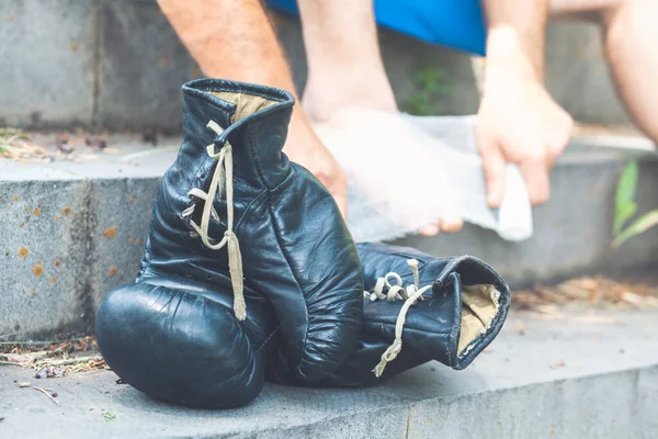 街上灰色的楼梯上躺着两个用皮革制成的黑色运动拳击手套 — 图库照片