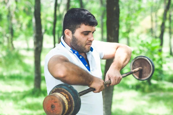 スポーティ男でAホワイトTシャツとショートパンツピックアップ重いベルで自然 — ストック写真