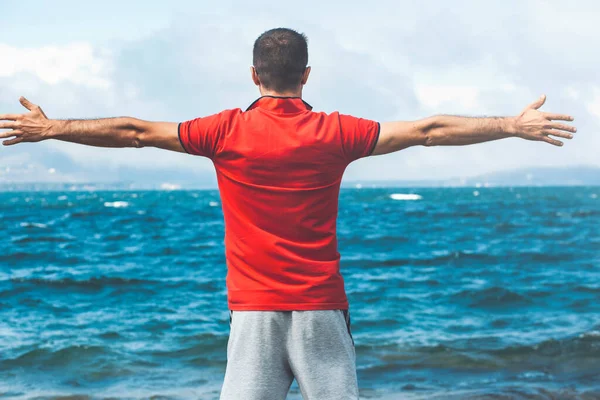 Mutlu, heyecanlı, heyecanlı, gezgin ve hipster 'ın kollarını mavi gökyüzüne kaldırması kumsalda özgürce gezinip güzel manzaranın tadını çıkarması tatil, özgürlük kavramı.