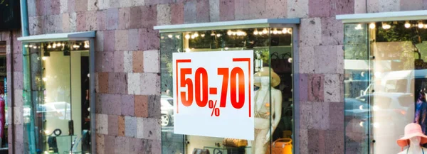 Advertising sign sale behind glass shop windows.