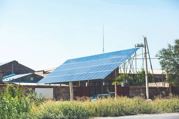 地面和杆子安装的住宅太阳能电池板 可再生能源系统安装在房子附近的菜园 — 图库照片