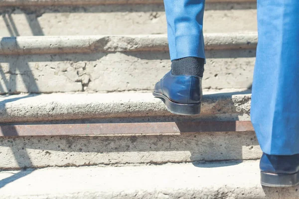 Close up legs shoes of young business man one person walking stepping going up the stairs in modern city, go up, success, grow up