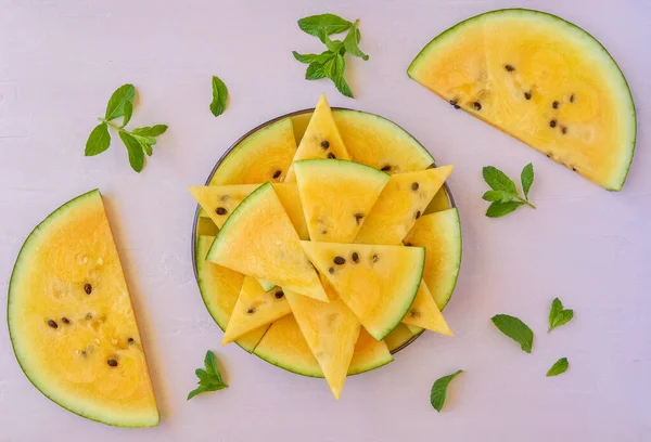 Sliced yellow watermelon on pink background. Top view