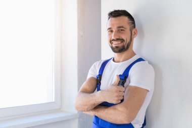 Tulumlu müteahhit kollarını göğsünün üzerine kavuşturmuş.