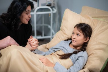 Sevgi dolu bir anne, küçük kızına yatakta bir hikaye anlatıyor.