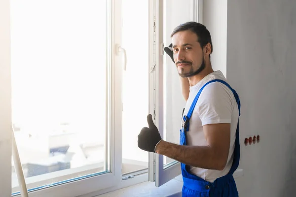 Mężczyzna instaluje okno i pokazuje kciuk — Zdjęcie stockowe