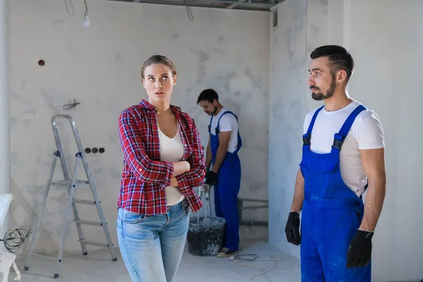 La mujer está decepcionada con la forma en que el capataz renueva el apartamento — Foto de Stock