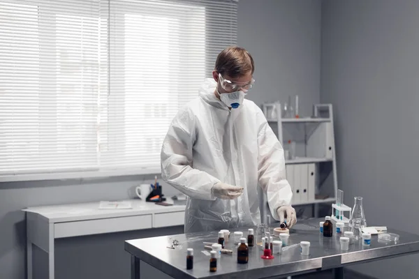Um jovem químico, estudante a fazer experiências num laboratório escolar — Fotografia de Stock