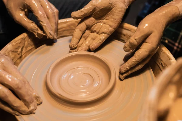 Teacher and student sculpt a pot of clay on a Potters wheel, close-up. — Stock Photo, Image