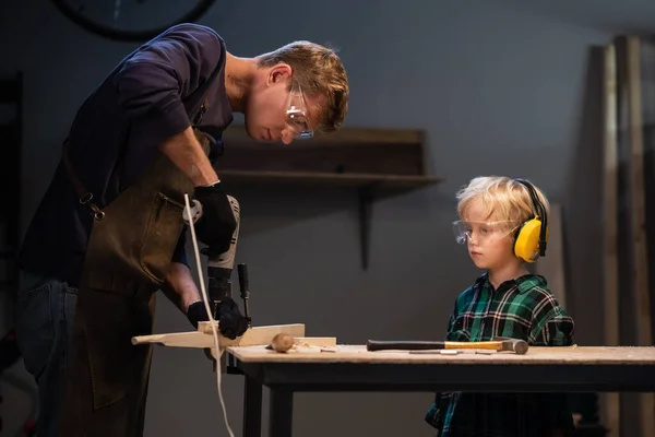 brothers prepare a gift made of wood for their mother in the garage.