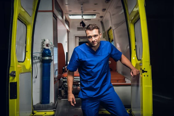 Un joven paramédico saliendo de un coche ambulancia —  Fotos de Stock