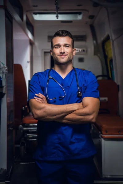 Un retrato de tres cuartos de un joven paramédico guapo con las manos dobladas —  Fotos de Stock