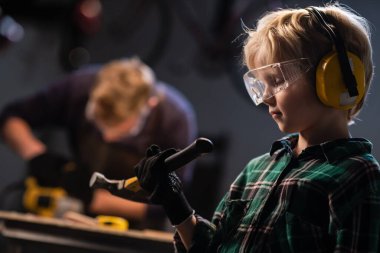 Marangozhanede işçi öğretmeni olan küçük bir çocuk..