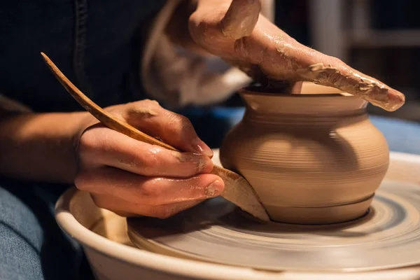 A master in a pottery workshop shows the technique of modeling a pot on a Potters wheel. — Stock Photo, Image