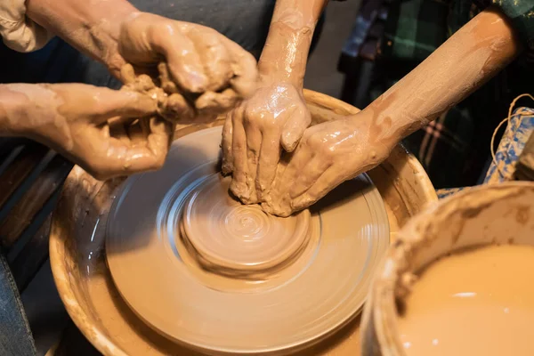 Close-up of the hands of a woman and child in clay in a pottery workshop. — Stock Photo, Image