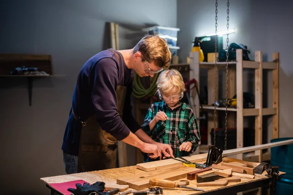 brothers prepare a gift made of wood for their mother in the garage.