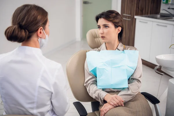 Uma dentista do sexo feminino consulta sobre sua condição de pacientes — Fotografia de Stock