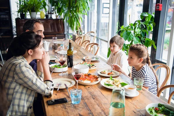 Een gezin van vier met een brunch in een café in het weekend — Stockfoto
