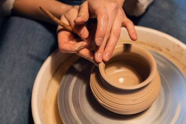 Çömlekçilik atölyesinde bir usta çömlekçi çarkında bir kap modelleme tekniğini gösterir..