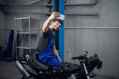 Bisiklette oturan bir adam fotoğraf için poz veriyor.