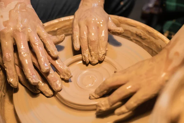 Close-up of the hands of a woman and child in clay in a pottery workshop. — Stock Photo, Image