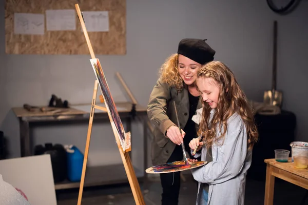 Joint work of two artists. Young funny girls draw a picture in the artists Studio. — Stock Photo, Image