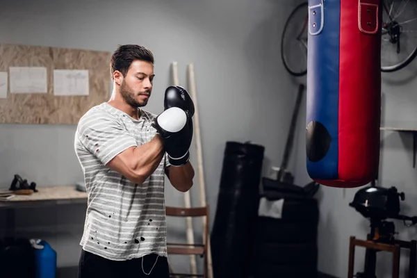 Deneyimli bir sporcu garajında boks antrenmanından önce ısınmaya hazırlanır..